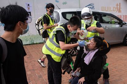 Con las calles repletas de manifestantes, la policía utilizó bastones de goma y gas pimienta para dispersar a un grupo de ellos que había instalado barricadas en el barrio de Wan Chai. En la imagen, varias personas ayudan a una afectado por el lanzamiento de gas pimienta durante las protestas, este lunes.