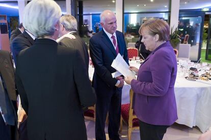 La canciller alemana, Angela Merkel, revisa una documentación en presencia del primer ministro griego, Yorgos Papandreu , y de la directora general del Fondo Monetario Internacional (FMI), Christine Lagarde durante un encuentro especial convocado para hablar sobre la crisis del euro en el ámbito de la cumbre del G-20 en Cannes.