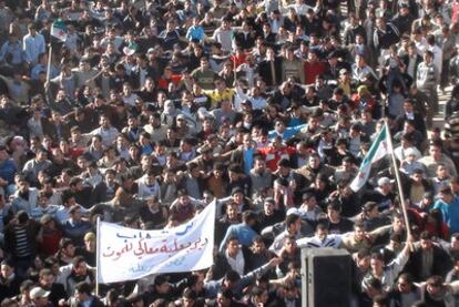 Manifestantes sirios contra Bachar el Asad, el domingo en Deir Balaba, cerca de Homs, la ciudad con más protestas. La pancarta dice: "Deir Balaba apoya a Homs".