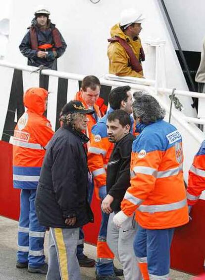 José Manuel Parada (con jersey), uno de los marineros rescatados, a su llegada al puerto de Oza.