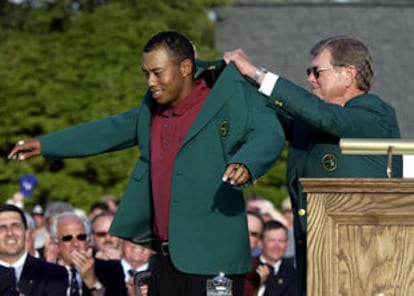 Hootie Johnson, presidente del Club de Golf de Augusta, viste a Toger Woods su tercera chaqueta verde.