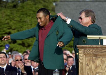 Hootie Johnson, presidente del Club de Golf de Augusta, viste a Toger Woods su tercera chaqueta verde.