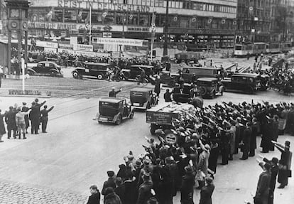 En Berlín de 1933, los viandantes saludan a Hitler, mientras da el discurso de victoria de las elecciones de 1933.