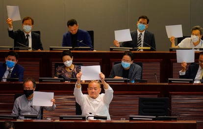 Legisladores de la oposición demócrata levantan papeles en blanco como protesta durante una reunión parlamentaria para tratar sobre la nueva Ley de Seguridad Nacional.