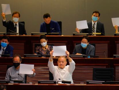 Legisladores de la oposición demócrata levantan papeles en blanco como protesta durante una reunión parlamentaria para tratar sobre la nueva Ley de Seguridad Nacional.