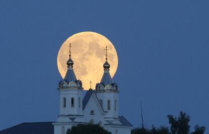 A lua vista entre as torres de uma igreja ortodoxa em Novogrudok (Bielorrússia).