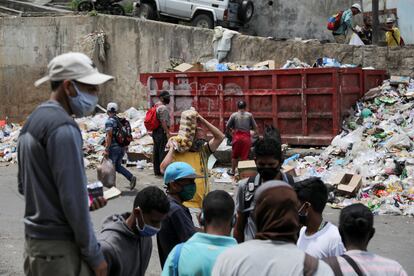 Un grupo de personas se junta frente a un contenedor de basura en el barrio de Petare, en Caracas, el 4 de agosto.