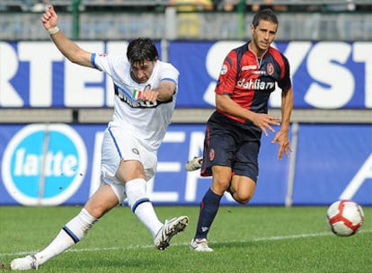 Diego Milito, de blanco, marca uno de sus dos goles frente al Cagliari.