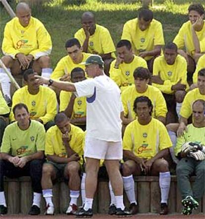 Scolari da instrucciones a los jugadores de Brasil, que le escuchan sentados en la grada.