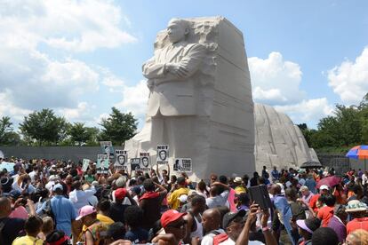 Una multitud se reúne alrededor de la piedra de la esperanza en el Memorial Martin Luther King. Algunas pancartas recuerdan a jóvenes negros asesinados, entre ellos Trayvon Martin con las palabras "No culpable".