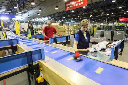 Trabajadores en la central de distribución de Correos clasifican las cartas en el Centro de Tratamiento Automatizado (CTA) en un polígono de Vallecas (Madrid).