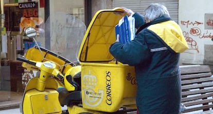 Un cartero de Lugo con la moto que usa para el reparto, en una imagen de archivo.  