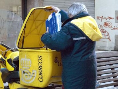 Un cartero de Lugo con la moto que usa para el reparto, en una imagen de archivo.  