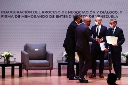 El jefe de la oposición y un delegado del Gobierno venezolano se saludan tras las reuniones en Ciudad de México.