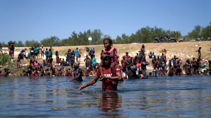 Um homem com uma menina sobre seus ombros cruza o rio Grande dos Estados Unidos para o México. Em vídeo, imagens dos migrantes na fronteira com o México. 