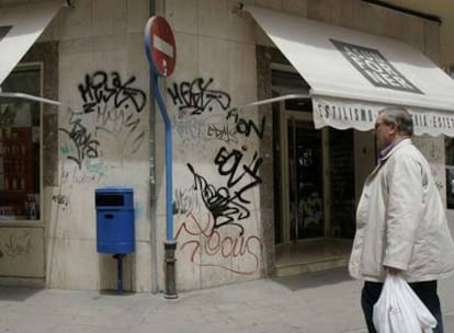 La fachada de un comercio de Alicante, llena de pintadas.