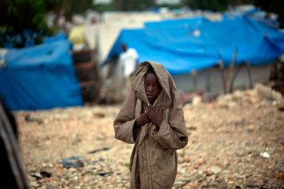 Un niños se cubre con una chaqueta en un campo de refugiados de Puerto Príncipe, donde están amenazados ante la llegada del huracán Tomas.