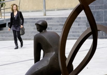 Una mujer observa una escultura de la artista Rosa Serra instalada en la plaza de Can Mario de Palafrugell que un Jardín de Esculturas cedido por la Fundación Vila Casas.