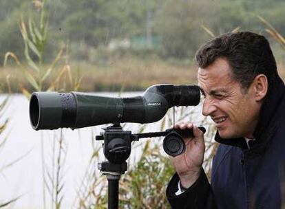 Nicolas Sarkozy observa a través de un catalejo en su visita de ayer a una reserva de aves en Biguglia, Córcega.