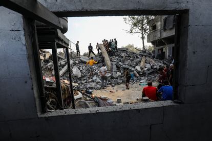 Palestinos buscan víctimas entre los restos de la casa de la familia Tahravi, que fue destruida por las ataques israelíes, en Rafah (Gaza). 