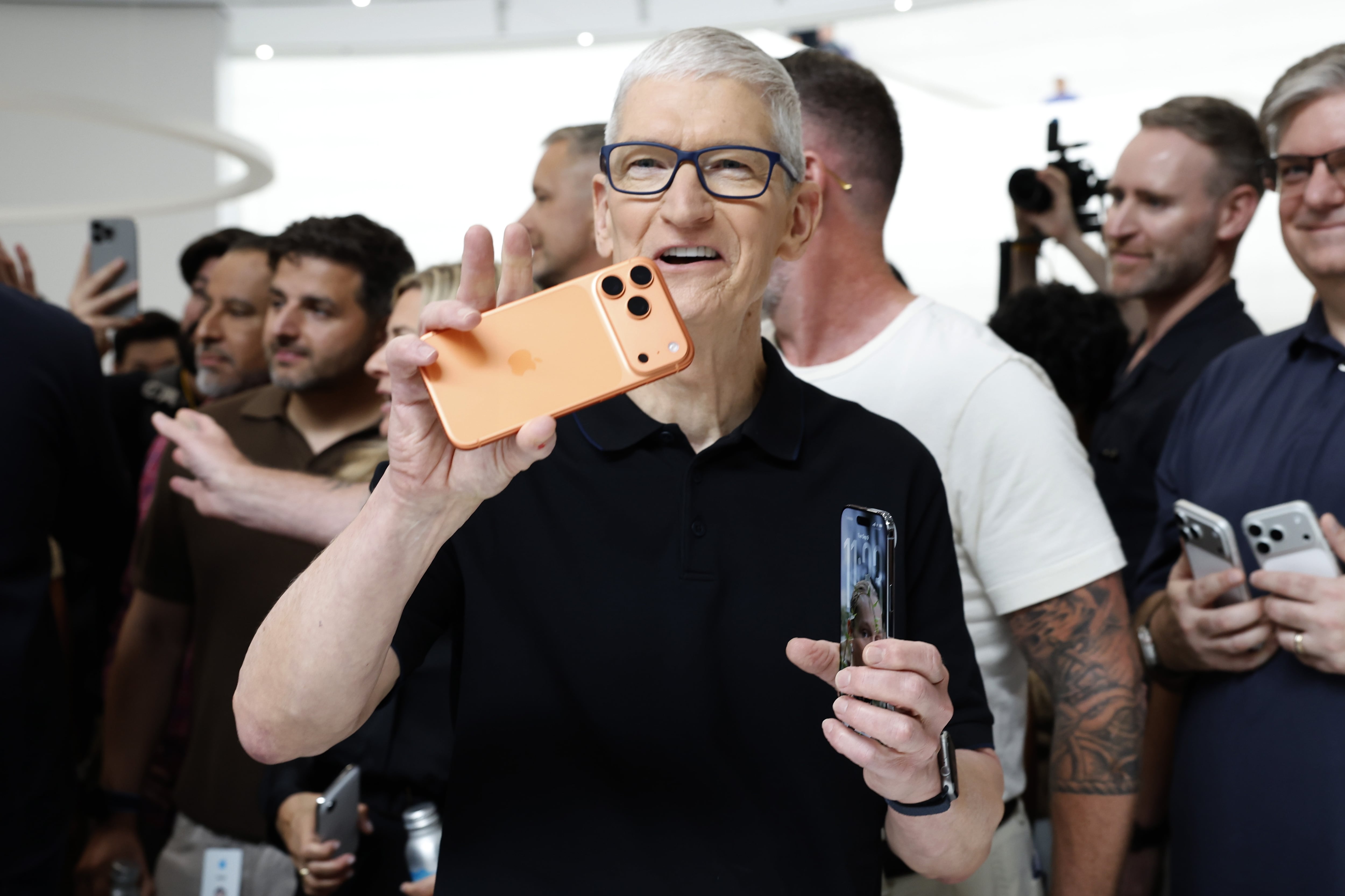 Tim Cook, CEO de Apple, sostiene los nuevos iPhone.