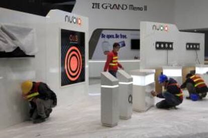 Unos trabajadores ultiman los detalles en el recinto ferial de Gran Vía donde hoy se inaugura el Mobile World Congress, el mayor evento mundial de tecnología móvil, que entre el 24 y 27 de febrero reunirá a 75.000 asistentes de 200 países.