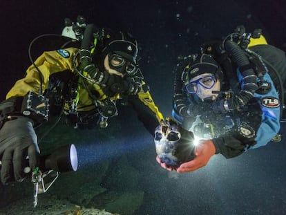 Os mergulhadores Alberto Nava e Susan Bird com o crânio de uma menina de 12.000 anos, descoberto em uma gruta alagada do Yucatán.