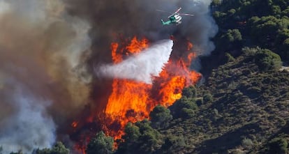 Un helicóptero trabaja en el control de las llamas.