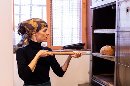 Ignacia Moreno saca un pan del horno de su obrador.