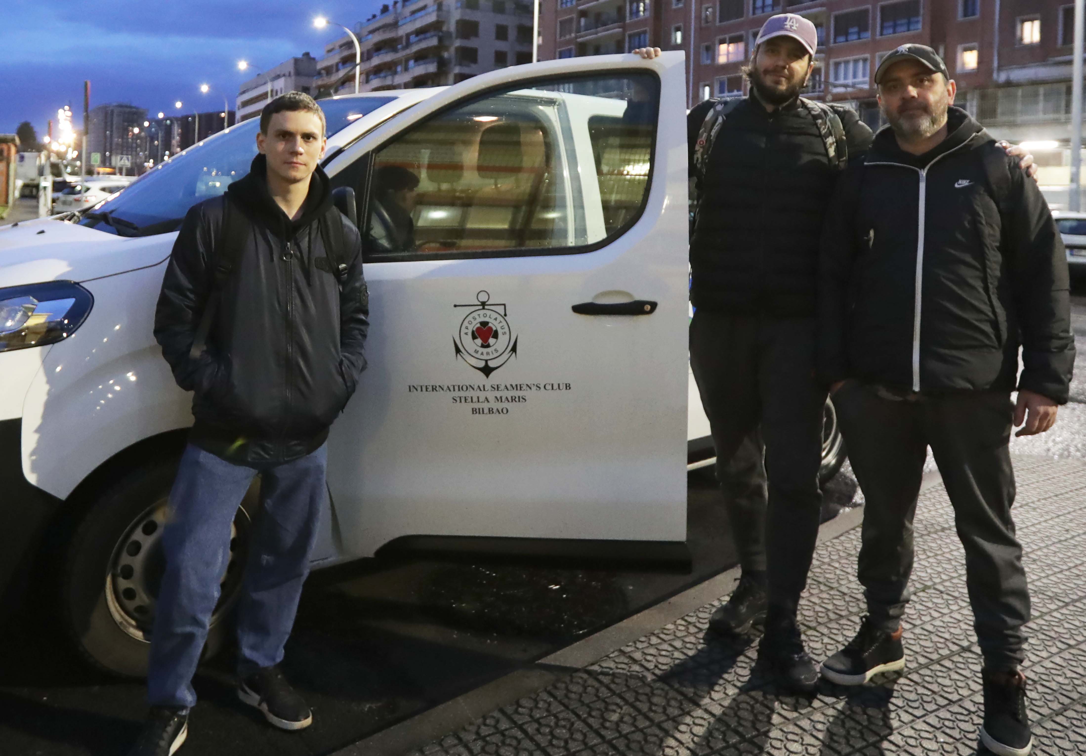 Marinos ucranianos, de la tripulación del carguero 'Longuera', de bandera holandesa, junto a un coche del centro Estella Maris en el puerto de Santurtzi (Bizkaia).