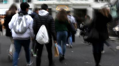 Varios jóvenes caminan por la gran Vía de Madrid.