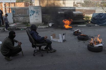 Manifestantes palestinos enmascarados queman llantas en una protesta contra una incursión mortal del ejército israelí en el campo de refugiados de Aida, en la ciudad de Belén, Cisjordania.