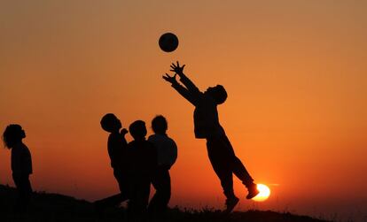 Meninos palestinos jogam o futebol na cidade de Ramala, durante o pôr do sol, em 10 de abril de 2014.