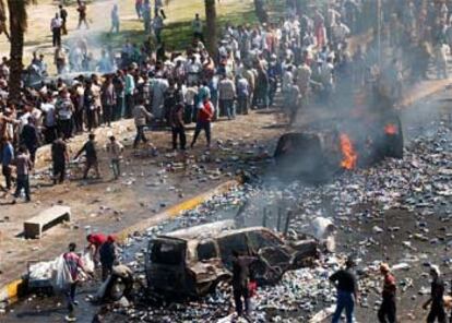 Una multitud se concentra ante el convoy que fue objeto del atentado en el centro de Bagdad.