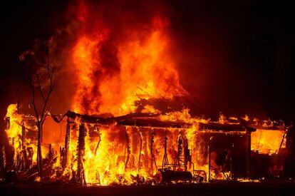 La portavoz del departamento Forestal y de Protección contra Incendios de California Lynn Valentine ha confirmado que una persona ha muerto, aunque ha asegurado no tener información acerca del fallecido. En la imagen, una casa es devorada por las llamas en Seigler Springs, California.