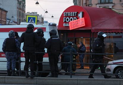 Agentes de las fuerzas de seguridad y miembros de los servicios de emergencias, junto al café donde se ha producido el atentado, en San Petersburgo.