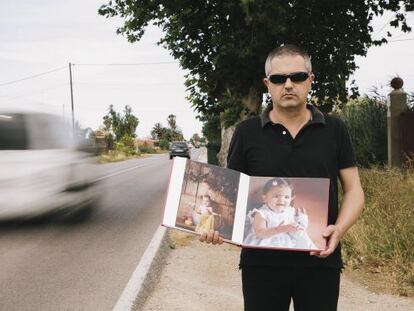 Antonio &Aacute;ngel Pertusa holds pictures of his daughter Julia near the scene of the accident.