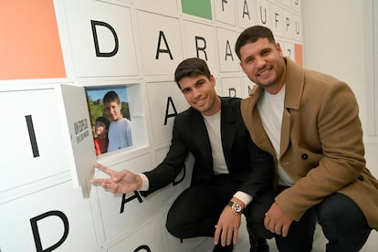 El tenista Carlos Alcaraz inaugura su exposición en la Cárcel Vieja de Murcia, el 14 de diciembre. En la imagen, Alcaraz posa con su hermano Álvaro junto a una foto de ambos. 