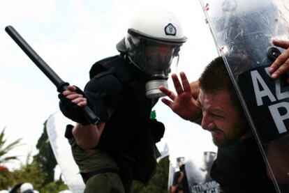 La policía carga contra un manifestante ayer en las protestas de Atenas.