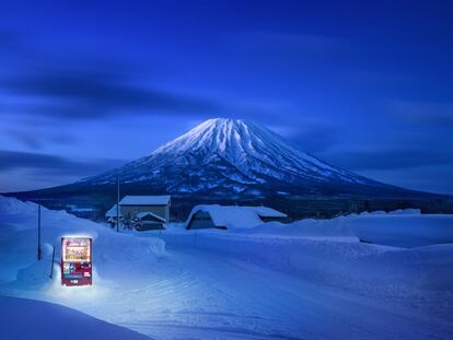 <p>Kutchan, Hokkaido, Japón (Roadside Lights III).</p><br><p>Imagínese a alguien usando esta máquina expendedora. En serio, inténtelo. Quizás un viajero cansado que se detiene en el arcén y se apea del coche. Se le ha antojado un refresco. Camina hacia la luz, sintiendo cómo la nieve le cala los zapatos. Se quita los guantes, introduce las monedas y con los dedos entumecidos pulsa la combinación alfanumérica. Imagínese el estrépito de la lata al caer. Ahora el silencio de después. Es difícil, ¿verdad? Eso mismo debió de pensar Eiji Ohashi, el autor de esta fotografía. Ha plasmado el panorama que ha dejado la proliferación de máquinas expendedoras en Japón en su serie de publicaciones <i>Roadside Lights</i> (editorial Case). Hay cinco millones de ellas en todo el país, una por cada 23 personas. El álbum está compuesto por una serie de fotos de neveras resplandecientes en paisajes inverosímiles: llanuras nevadas, playas desiertas, descampados baldíos o volcanes dormidos, como el que se ve al fondo, conocido como monte Yotei. En el límite entre un set publicitario y una postal surrealista. </p>