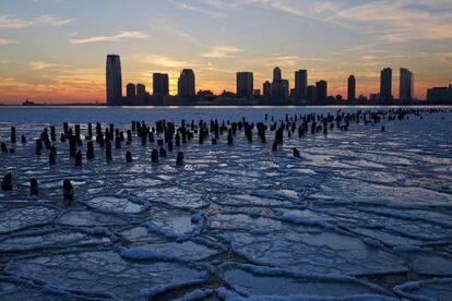 Enormes placas de hielo cubren en r&iacute;o Hudson en Nueva York mientras el sol se esconde tras los edificios de Nueva Jersey. 