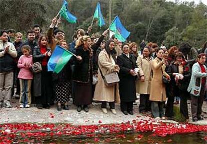 Un grupo de personas de etnia gitana lanzando ayer pétalos de rosas al río Ripoll.