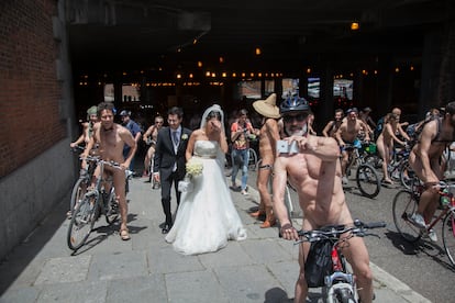 Una manifestación de ciclonudistas sorprende a una pareja de novios recién casados, en Madrid, en junio de 2014.
