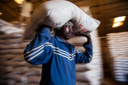 Un trabajador del Programa Mundial de Alimentos carga un saco de alimentos en El Fasher, Darfur.