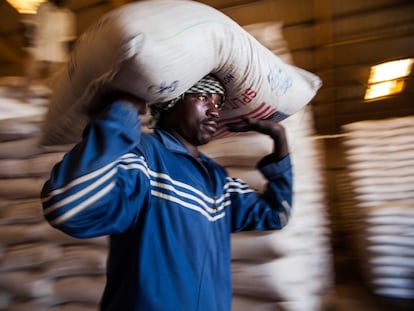 Un trabajador del Programa Mundial de Alimentos carga un saco de alimentos en El Fasher, Darfur.