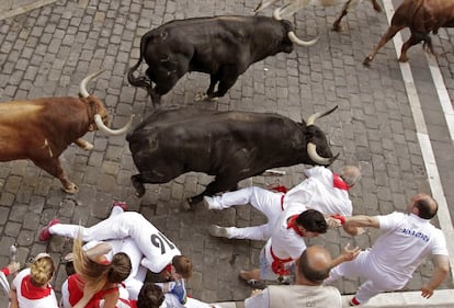 Un grupo de mozos caen ante tres toros en la entrada a la Plaza Consistorial de Pamplona.