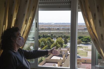 Una vecina observa las balsas desde su piso, en la barriada Pérez Cubillas de Huelva.