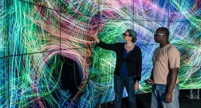 Dos personas examinan una proyección de conexiones cerebrales