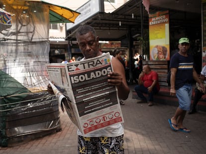 Un hombre lee un periódico con el titular en portugués "Aislado. Río en guerra contra el coronavirus" en Río de Janeiro, Brasil, el 20 de marzo de 2020.