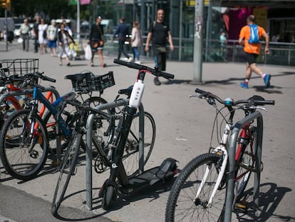 Un patinete eléctrico aparcado con una cadena en Barcelona.